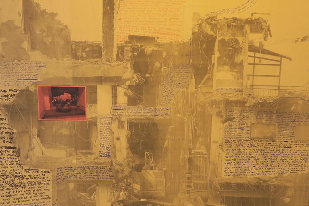 Collage. Gold-tinted black and white photographs are overlaid with areas of blue, black, and pink writing. The images are of a building that has been partially demolished so the facing wall is in ruins. A photograph of flowers in a vase, tinted coral pink, is collaged over the face of the building to our left.