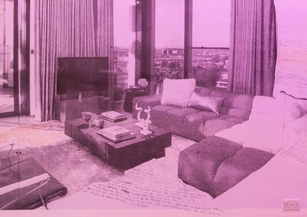 Installation. A violet-tinted black and white photograph shows a living room in a high-rise, the windows drawn back from floor-to-ceiling windows to show the city below. Writing has been added to the floor and walls.